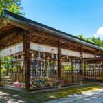 飛騨高山の櫻山八幡宮を舞台に、夏の青空と木造の絵馬殿、色とりどりの風鈴が涼やかに並ぶ実写風