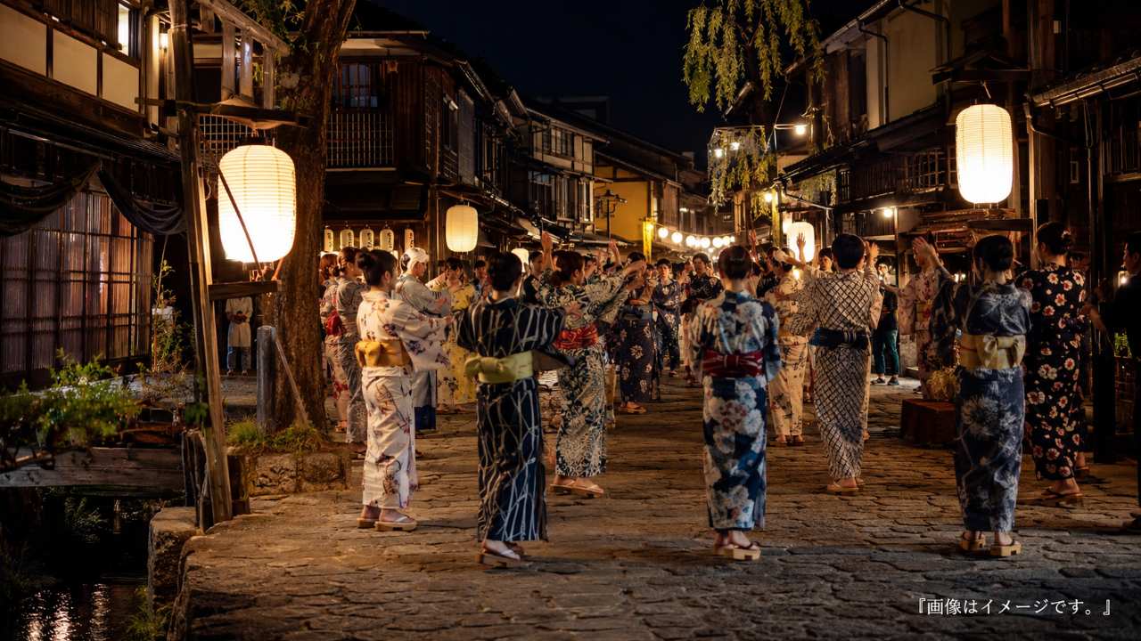 岐阜県郡上市の郡上八幡を舞台に、夏の夜、提灯の明かりの下で浴衣姿の人々が輪になって郡上おどりを楽しむ